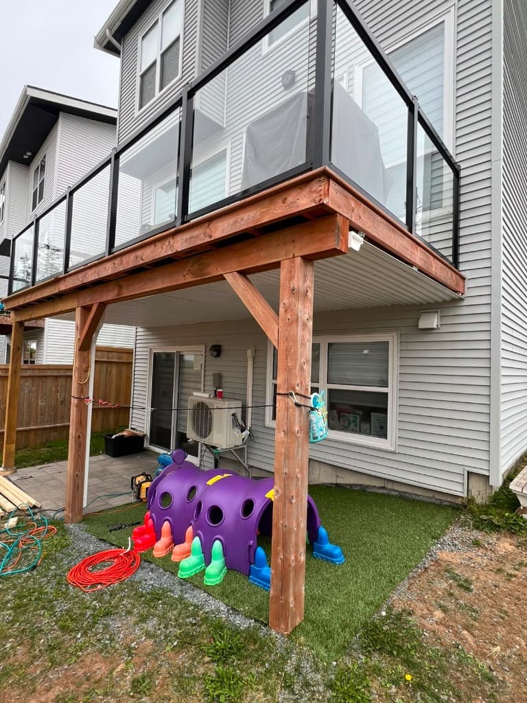 Custom deck with modern glass railings by Right On Contracting